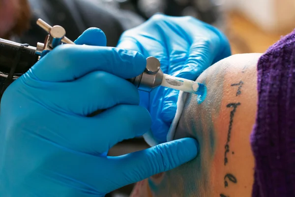 Mãos de tatuador criar uma tatuagem — Fotografia de Stock