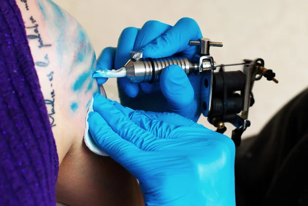 Hands of tattooist create a tattoo — Stock Photo, Image