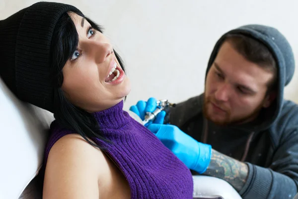 Emoties van een meisje terwijl het maken van een tatoeage — Stockfoto