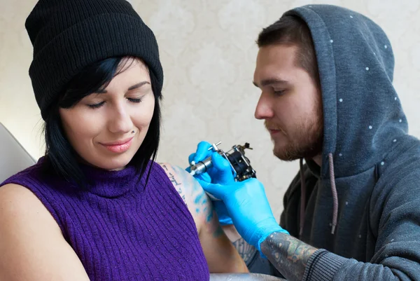 Emoties van een meisje terwijl het maken van een tatoeage — Stockfoto