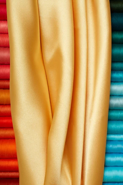 Farbige Spulen und goldene Seide — Stockfoto