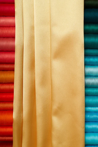 Gekleurde spoelkokers en gouden zijde — Stockfoto