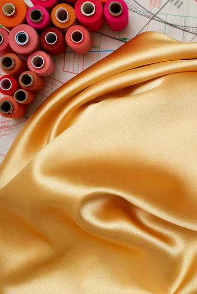 Цветные бобины и золотой шелк — стоковое фото