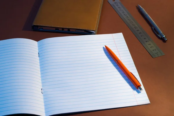 New lined exercise book with orange pen — Stock Photo, Image