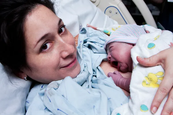 Happy mother holding newborn baby after birth — Stock Photo, Image