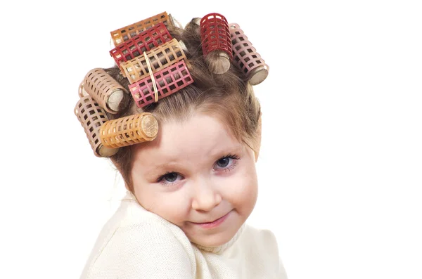 Schönes kleines Mädchen mit Lockenwicklern auf dem Kopf. — Stockfoto