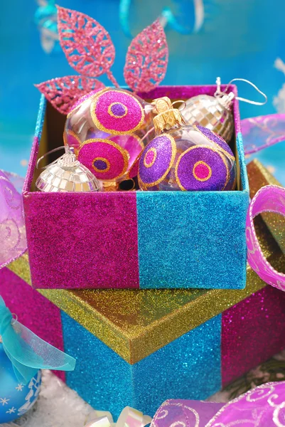 Colorful gift boxes with christmas baubles — Stock Photo, Image