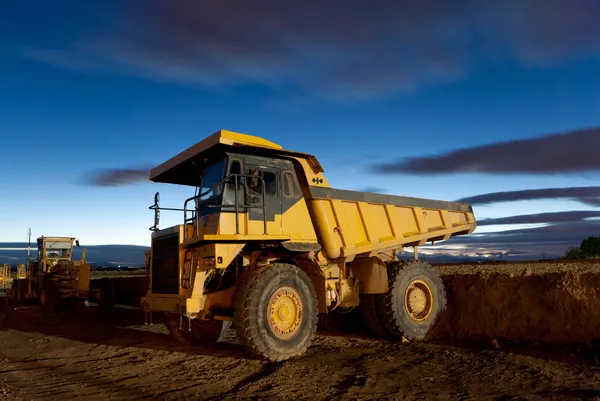 Enorme auto-dump amarelo mineração caminhão noite tiro e escavadeira Fotos De Bancos De Imagens