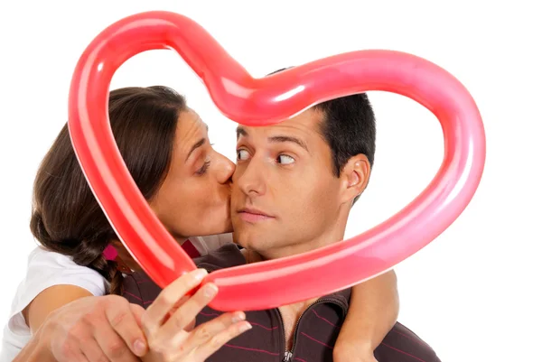 Genç bir çift balon kalp sürpriz ile izole öpüşme Stok Resim