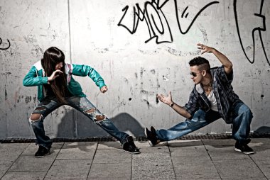 Young urban couple dancers hip hop dancing fight acting urban scene clipart