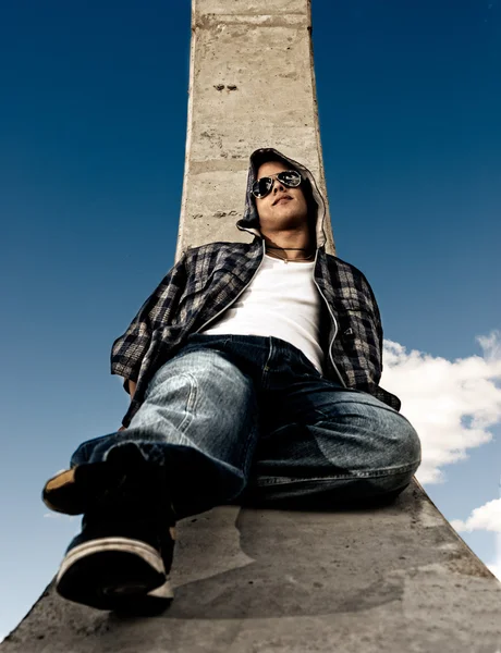 Fiatal férfi városi divat-portré át ég háttere — Stock Fotó
