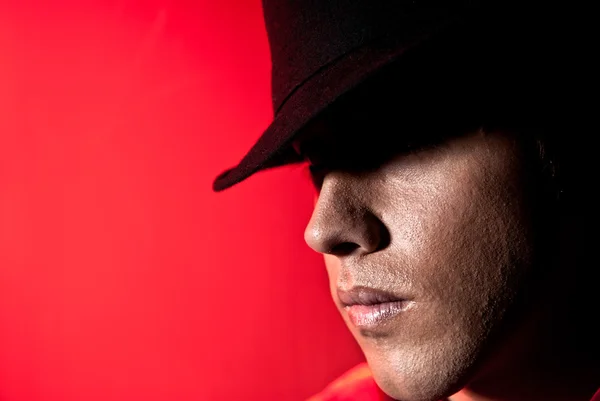 Chapeau homme beau portrait yeux sombres concept mistery fond rouge — Photo