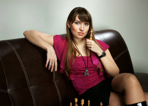 The girl with chess on a sofa — Stock Photo, Image