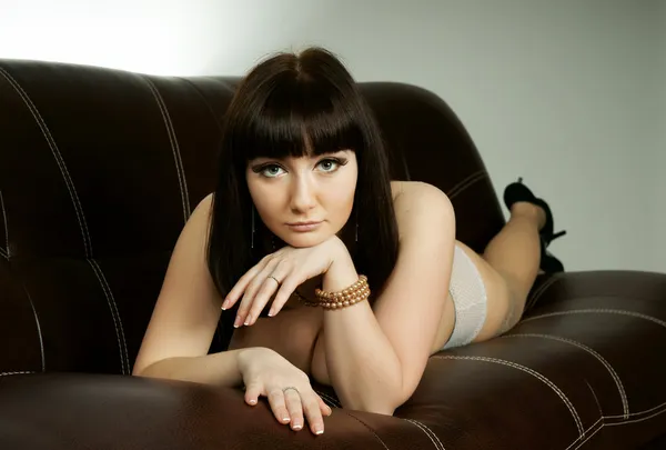 Красивая девушка в льняном белье на диване — стоковое фото