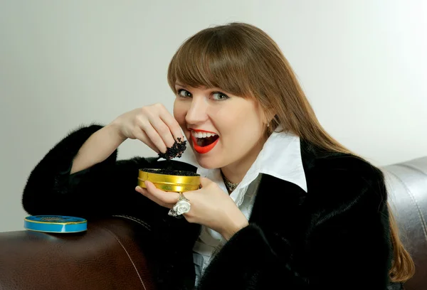 Das Mädchen isst schwarzen Kaviar — Stockfoto