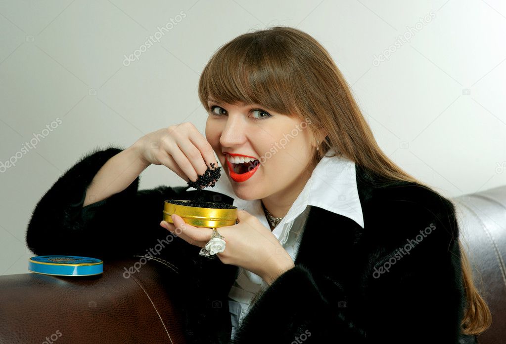 The girl eats black caviar