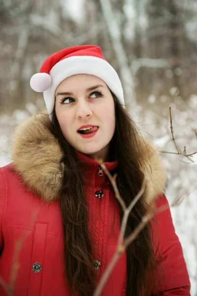 A menina em madeira em um chapéu de Papai Noel — Fotografia de Stock