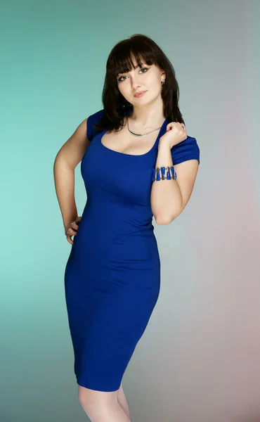 Piękna brunetka w ciemno niebieską sukienkę — Zdjęcie stockowe