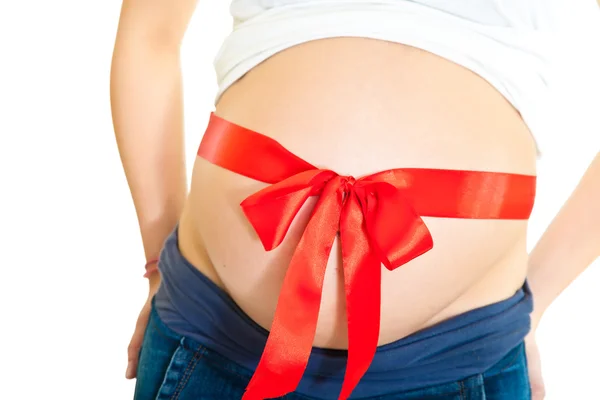 Брюнетка вагітна жінка з червоною стрічкою ізольовані на білому — стокове фото
