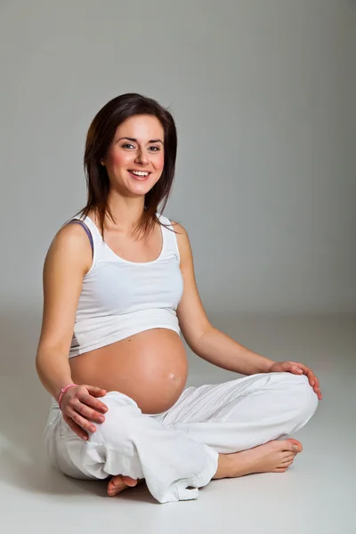 Nötr arka plan hamile esmer — Stok fotoğraf