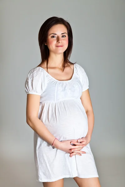 Ciąży brunetka na neutralnym tle — Zdjęcie stockowe