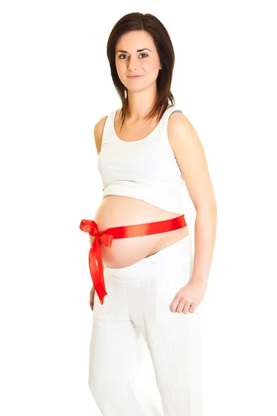 Bruneta těhotná žena s červenou mašlí izolované na bílém — Stock fotografie