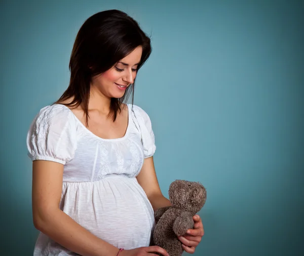 Беременная женщина на синем фоне — стоковое фото