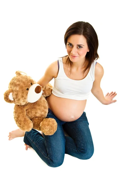 Брюнетка беременная женщина с плюшевым мишкой изолированы на белом — стоковое фото