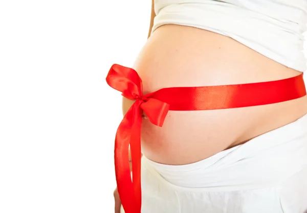 Brunette pregnant woman with red ribbon isolated on white — Stock Photo, Image