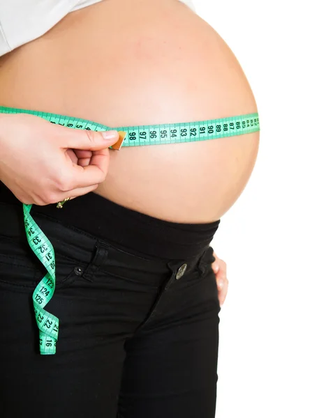 Zwangere vrouw meten buik geïsoleerd op wit — Stockfoto