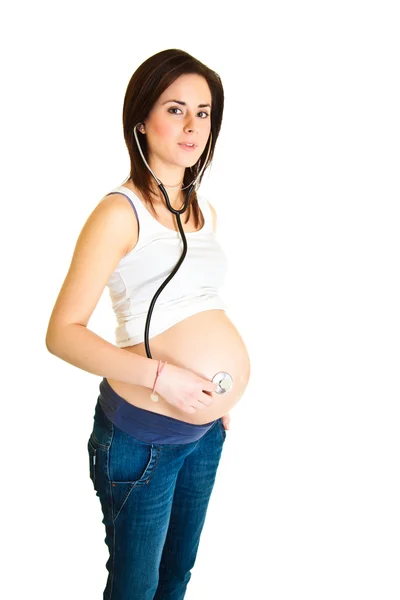 Mujer embarazada examinando el vientre con estetoscopio aislado —  Fotos de Stock