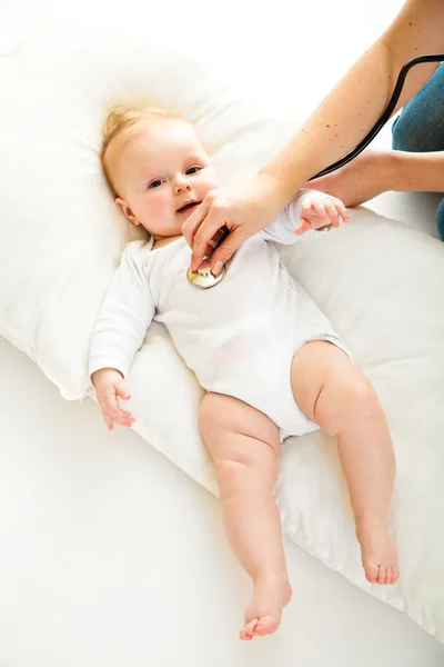 Mãe ausculating bonito bebê menina isolada no branco — Fotografia de Stock