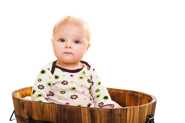 Cute infant girl sitting in wooden bucket — Stock Photo, Image