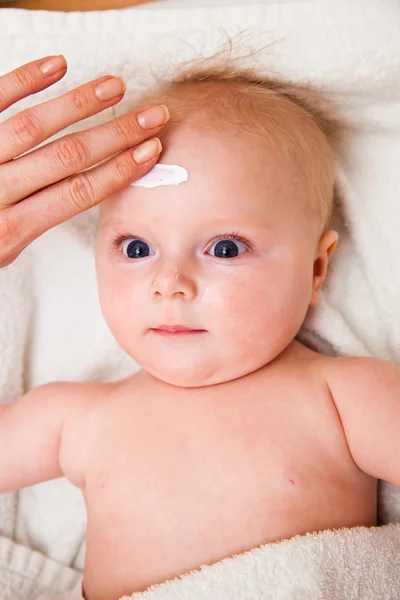 Mother creaming cute infant girl face — Stok fotoğraf