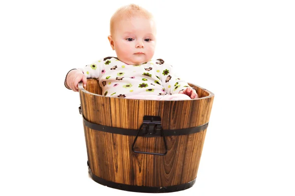 Cute infant girl sitting in wooden bucket — Stock Photo, Image