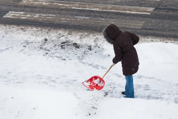 Femme pelletant neige — Photo