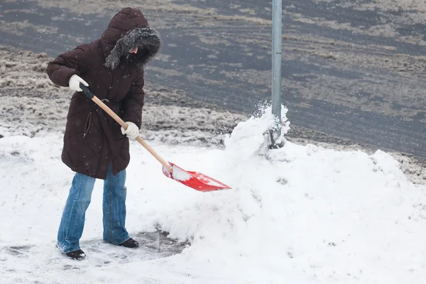 Femme pelletant neige — Photo