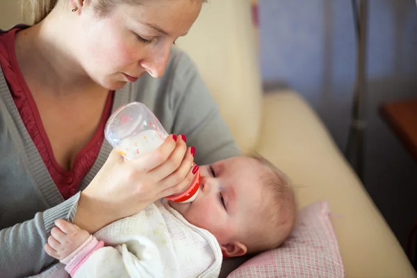 Madre lactante alimentación con un biberón de leche — Foto de Stock