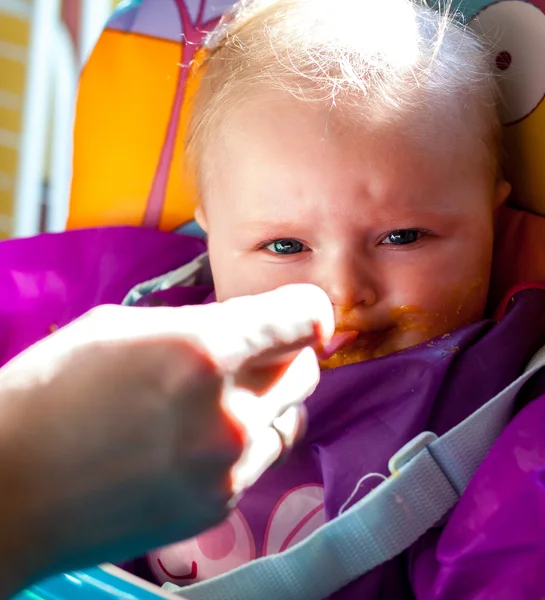 Infantil infeliz aprendiendo a comer alimentos sólidos —  Fotos de Stock