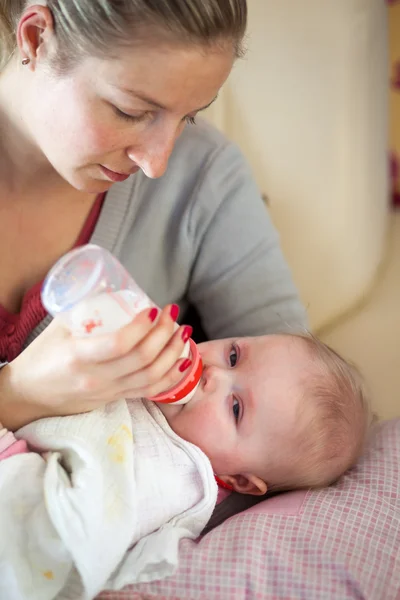 Mère nourrissant bébé fille avec une bouteille de lait — Photo
