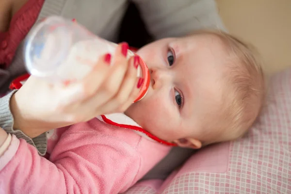 Anne bebek kız bir süt şişesiyle besleme — Stok fotoğraf