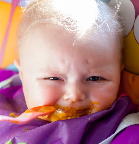 Enfant malheureux fille apprendre à manger de la nourriture solide — Photo