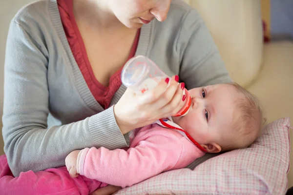 Mère nourrissant bébé fille avec une bouteille de lait — Photo