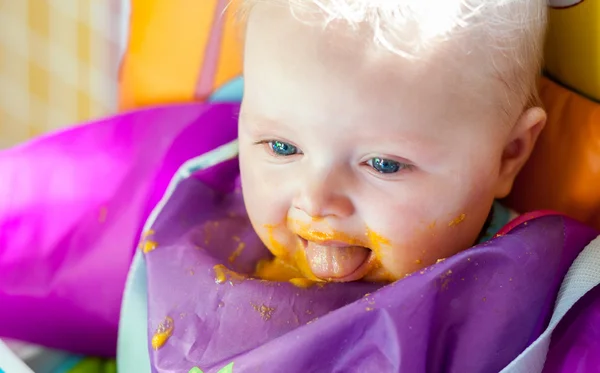 Niezadowolony dziewczyna niemowlę, ucząc się jeść pokarmów stałych — Zdjęcie stockowe