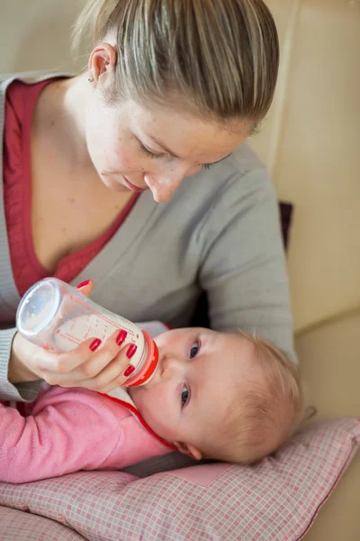 Madre lactante alimentación con un biberón de leche —  Fotos de Stock