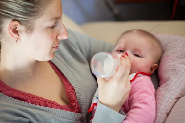 Mamma mata spädbarn flicka med en mjölkflaska — Stockfoto