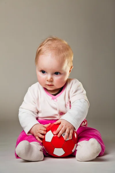 Spädbarn flicka som leker i rummet på trägolv — Stockfoto