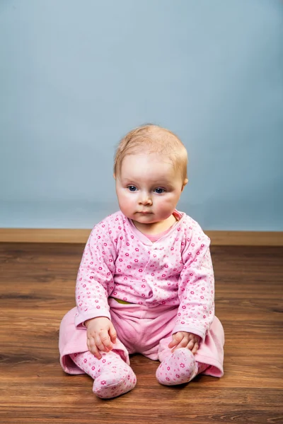 Söt spädbarn baby flicka sitter på golvet — Stockfoto