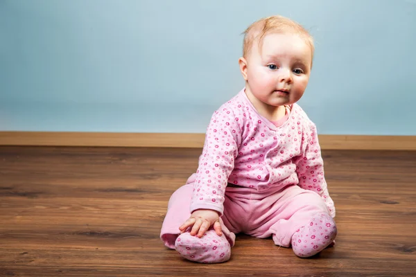 Linda niña bebé sentado en el suelo — Foto de Stock
