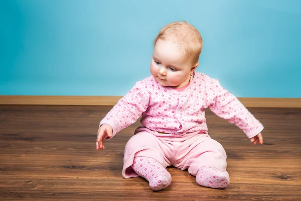 Cute infant baby girl sitting on the floor — Stock Photo, Image